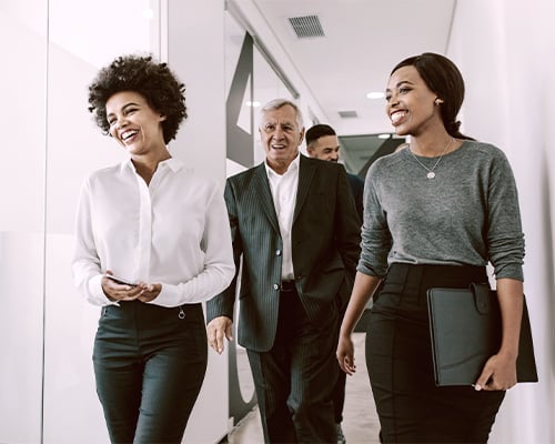 Diverse group of business people walking through office corridor.