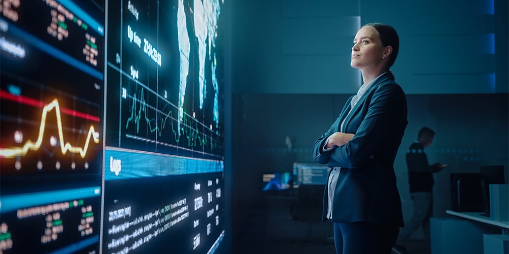 Woman looking at digital screens with her arms folded